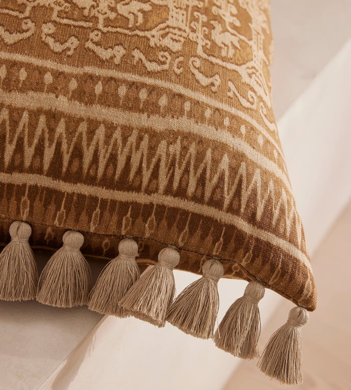Tan Patterned Pillow With Tassel Trim