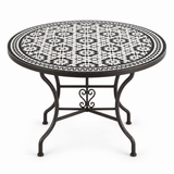 Round zellige mosaic dining table with bold black and white star-and-floral tile pattern and black wrought iron scrolled base