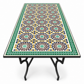 Large rectangular Moroccan zellige mosaic dining table with rich fish-scale tile pattern in olive green warm gold and moss with deep bronze-green border on matte black forged iron Y-fork leg base