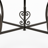 Dark bronze-black wrought iron table base with curved splaying legs X-cross stretcher brace and ornate heart-shaped scrolled motif at center junction