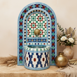 Moroccan blue arch mosaic fountain styled with lantern and botanicals on stone surface