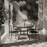 Zellige mosaic dining table on a covered Mediterranean terrace with climbing jasmine and dramatic shadows