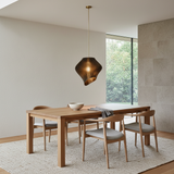 Smoke black sculptural pendant light above a contemporary dining table
