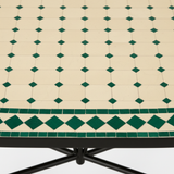 Close-up macro of ivory cream zellige mosaic tiles with small deep emerald green diamond dot accents and alternating ivory and green diamond border