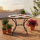Zellige mosaic dining table on a sunlit terracotta outdoor terrace with bougainvillea