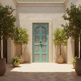 Blue floral Moroccan double door installed in a sunlit riad courtyard