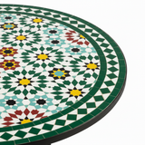 Close-up macro of emerald green red mustard yellow and cream Fez-style zellige star mosaic pattern with green diamond border