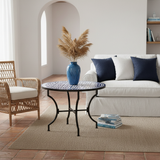 Cobalt blue and white zellige mosaic side table in a blue and white coastal living room with white linen sofa navy cushions arched doorway and rattan armchair