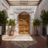 Natural wood hand-carved Moroccan double door installed in an elegant riad courtyard