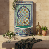 Moroccan zellige fountain styled with jasmine, brass lantern and mint on stone surface