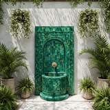 Green Moroccan mosaic fountain in whitewashed riad garden courtyard with tropical plants