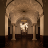 Cascading ribbed glass chandelier in a warm boutique hospitality interior